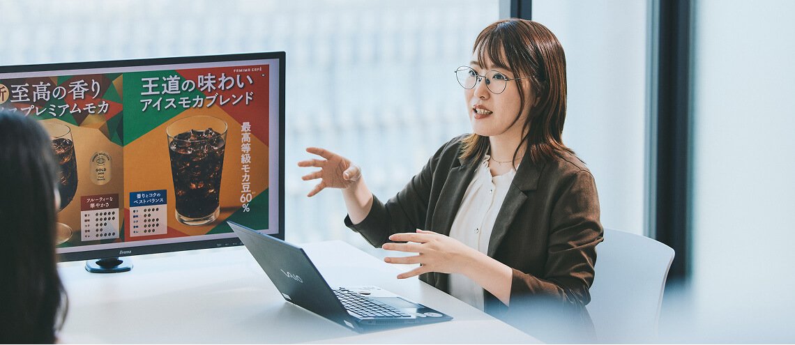 資料を提示しながらプレゼンする女性社員
